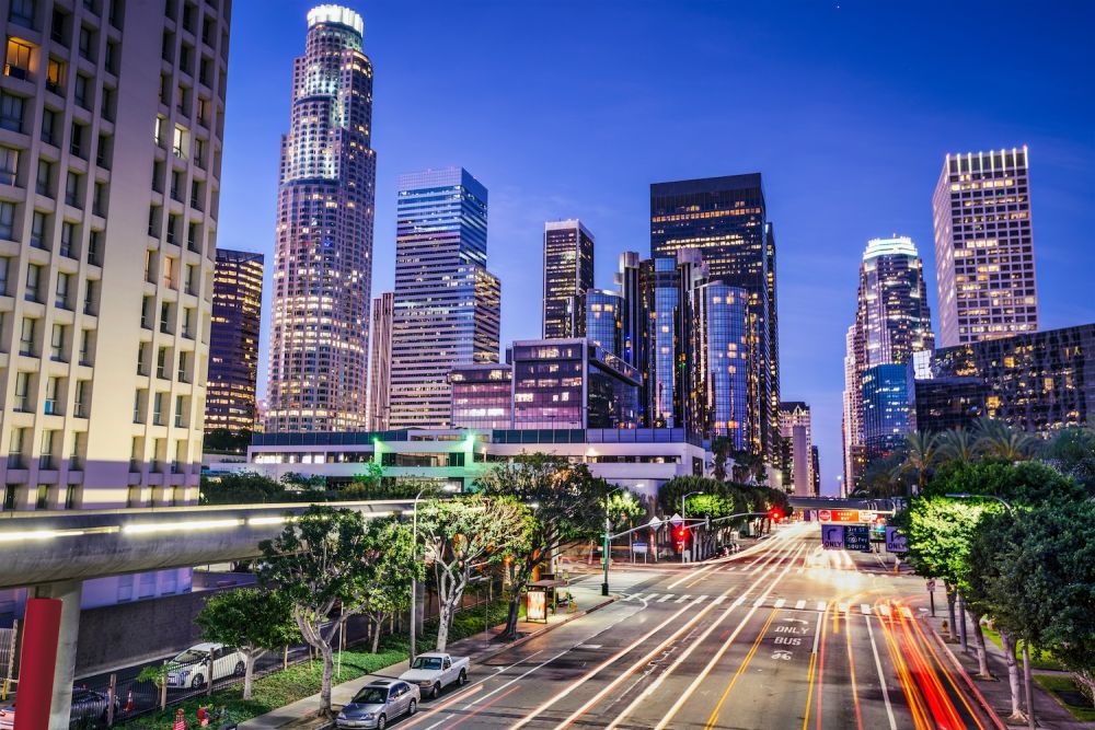 Downtown Los Angeles skyline at dusk with vibrant lights and traffic trails, showcasing urban life and architecture.